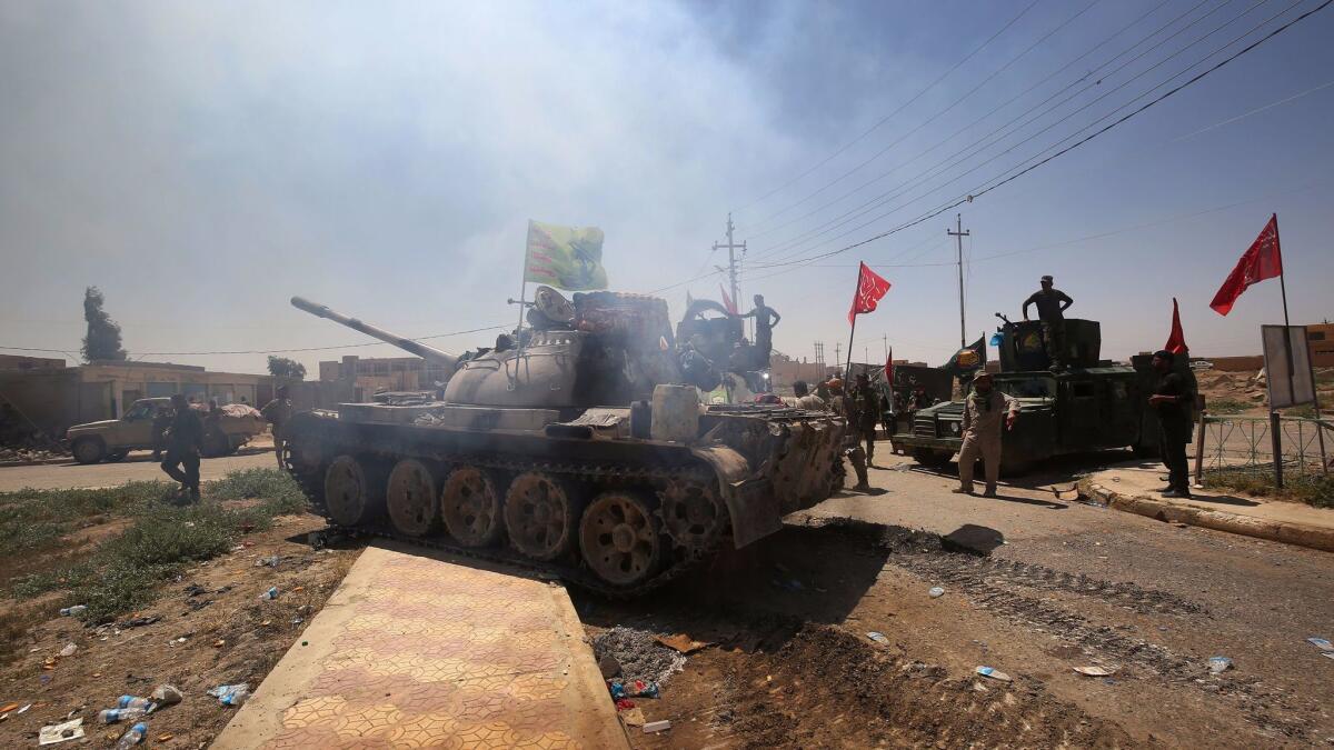 Pro-Iraqi paramilitary forces gather in a street in the town of Hatra, southwest of Mosul, on April 28, 2017.