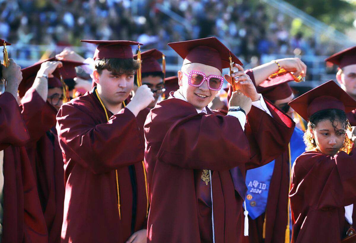 Graduates change their tassels from right to left confirming graduating during the Ocean View High graduation ceremony.