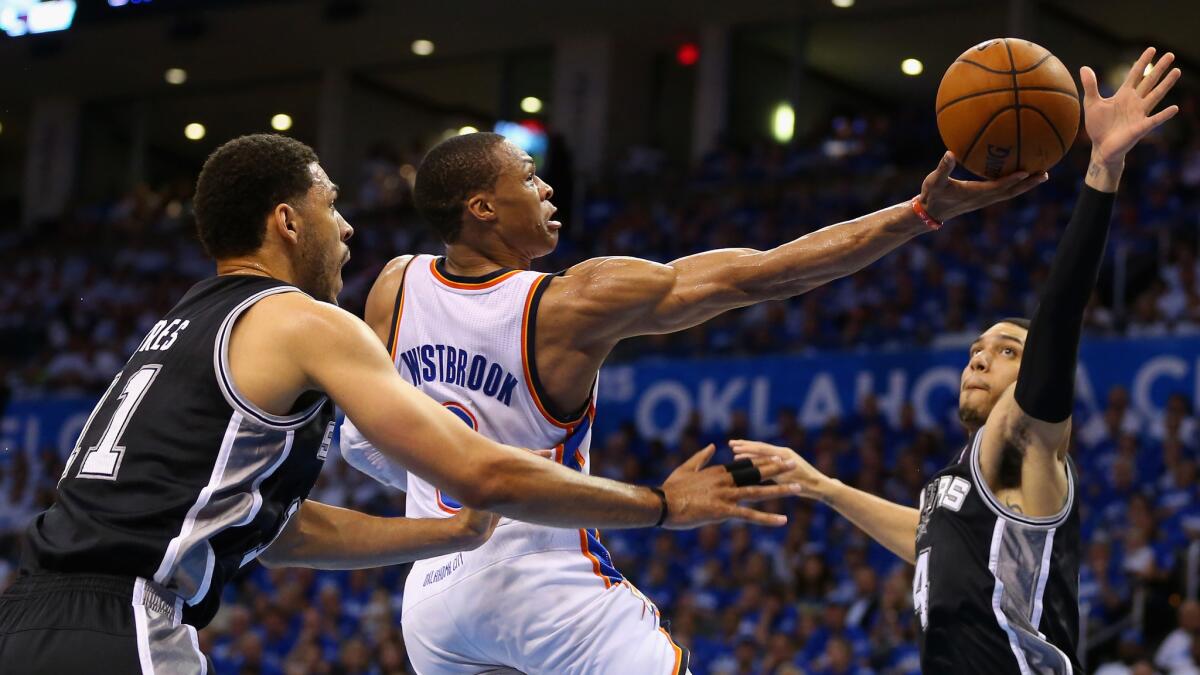 Oklahoma City Thunder point guard Russell Westbrook, center, puts up a shot between San Antonio Spurs teammates Jeff Ayres, left, and Danny Green during the second half of the Thunder's 105-92 win in Game 4 of the Western Conference finals Tuesday.