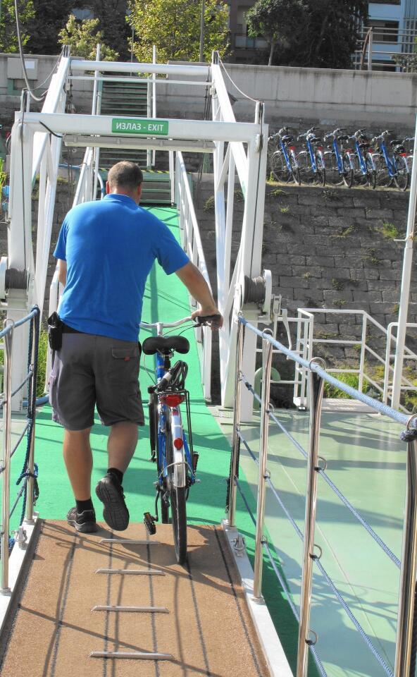 An AmaWaterways crew member wheels one of the on-board bikes from the storage space on the top deck.