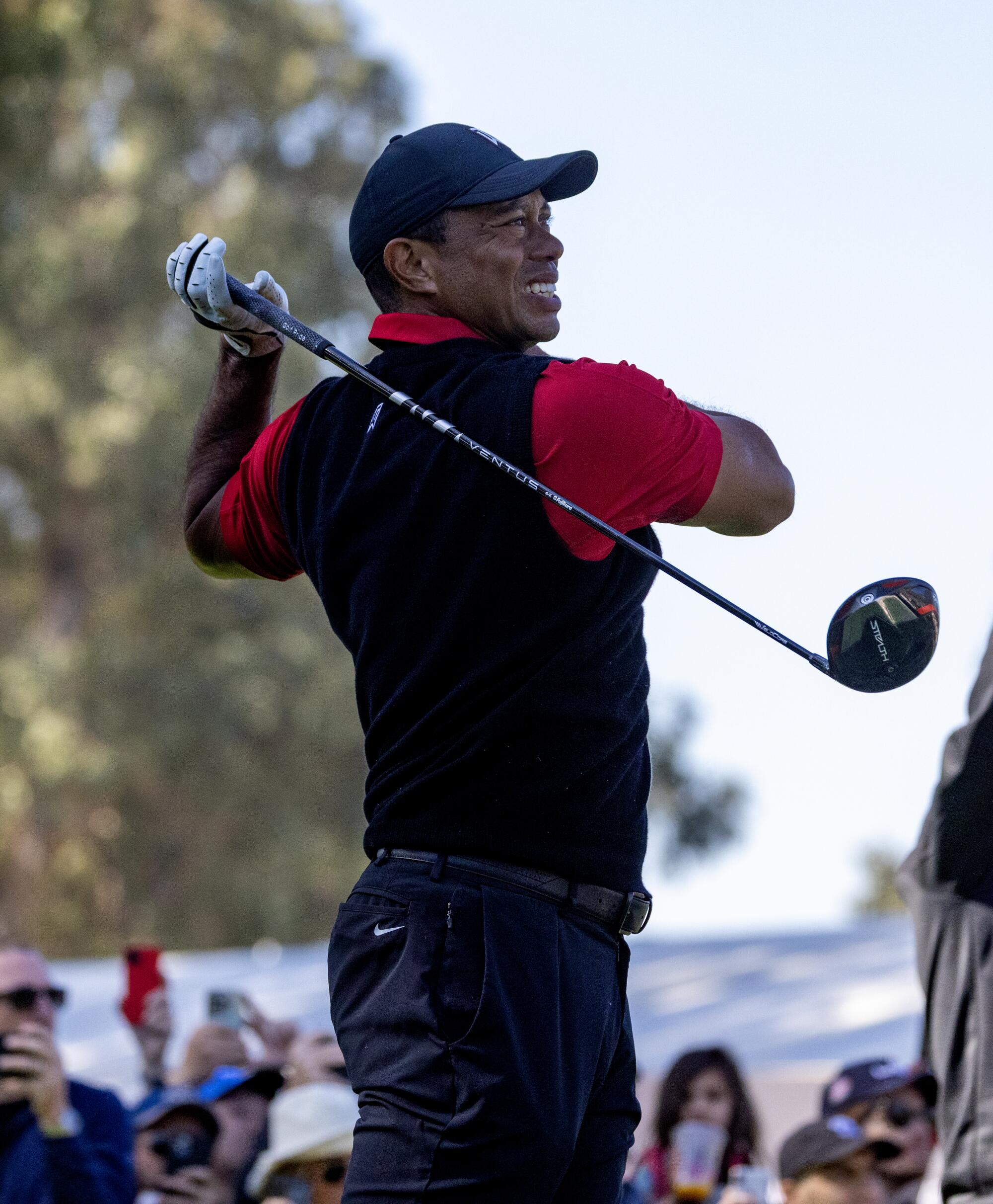 Tiger Woods lets go of his club while teeing off on the ninth hole during the final round.