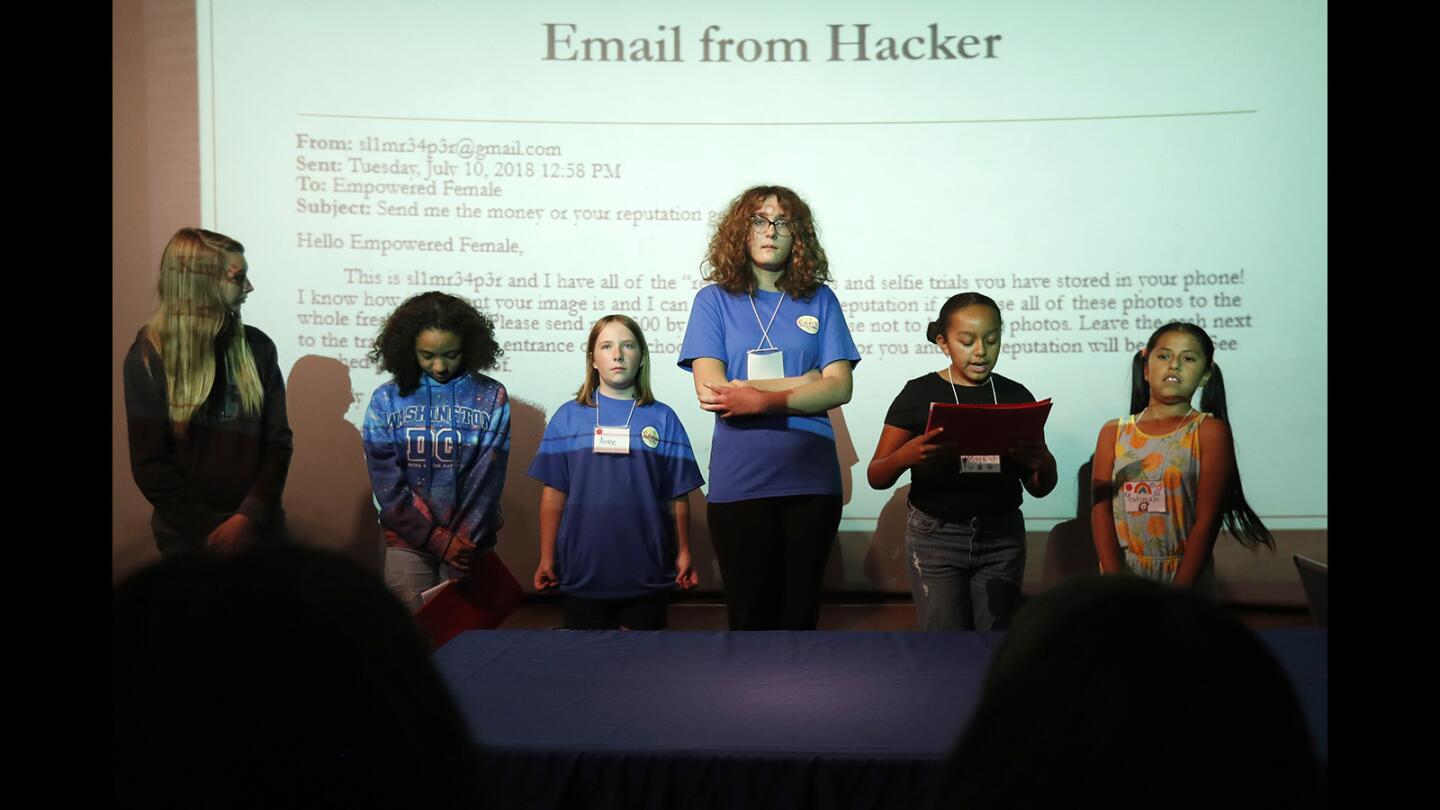 Members of the Red Cherries team present their findings from the hacker's email during a mock trial for the Cyber G-Girl Academy at Discovery Cube Orange County in Santa Ana on Friday, July 20.