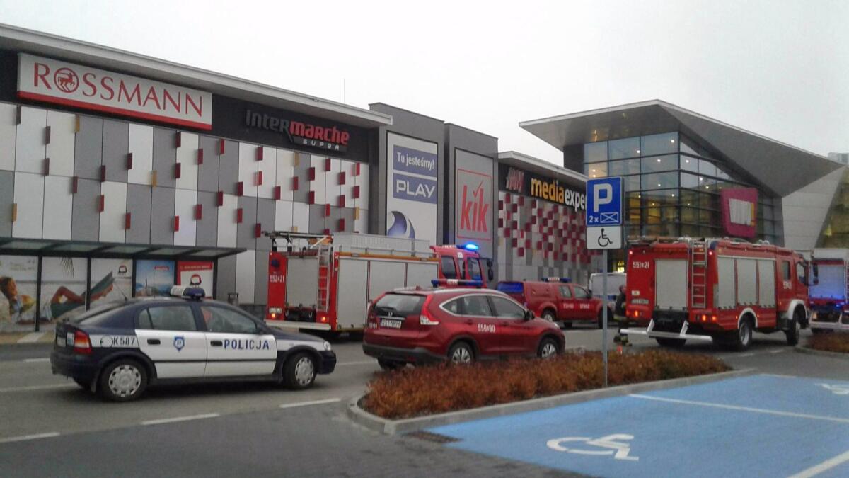 Police and firefighters' cars and trucks stand in front of the VIVO! shopping mall where a 27-year-old man attacked people with a knife killing one person and injuring several others in Stalowa Wola, southeastern Poland, on Friday, Oct. 20, 2017.