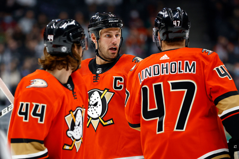 ANAHEIM, CALIFORNIA - DECEMBER 17: Ryan Getzlaf #15 talks to Hampus Lindholm #47 and Max Comtois.