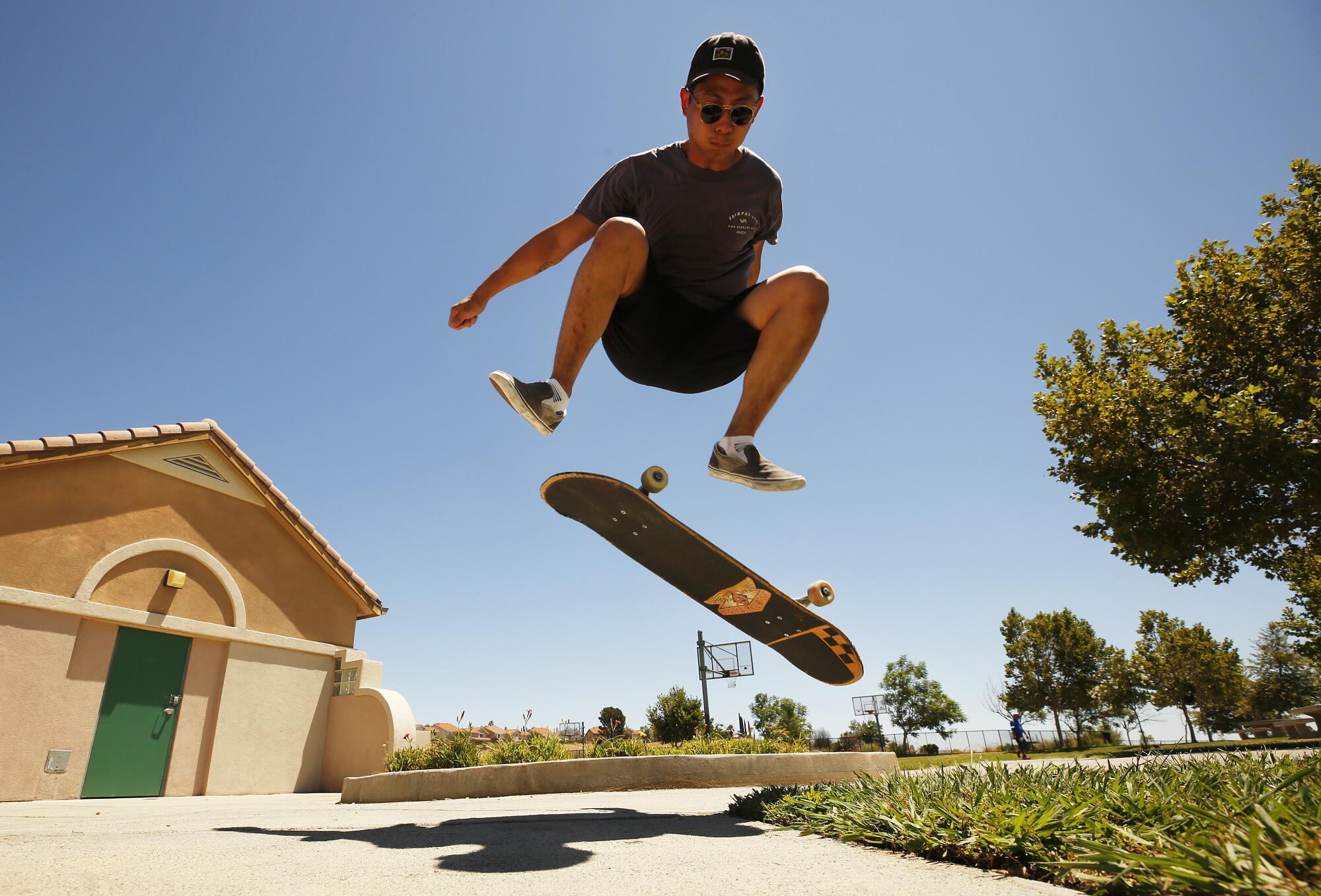 Brian Park, 27, takes a break from classes at CSUN to practice a Kickflip on his skateboard on Aug. 2 at Porter Ranch Park. 
