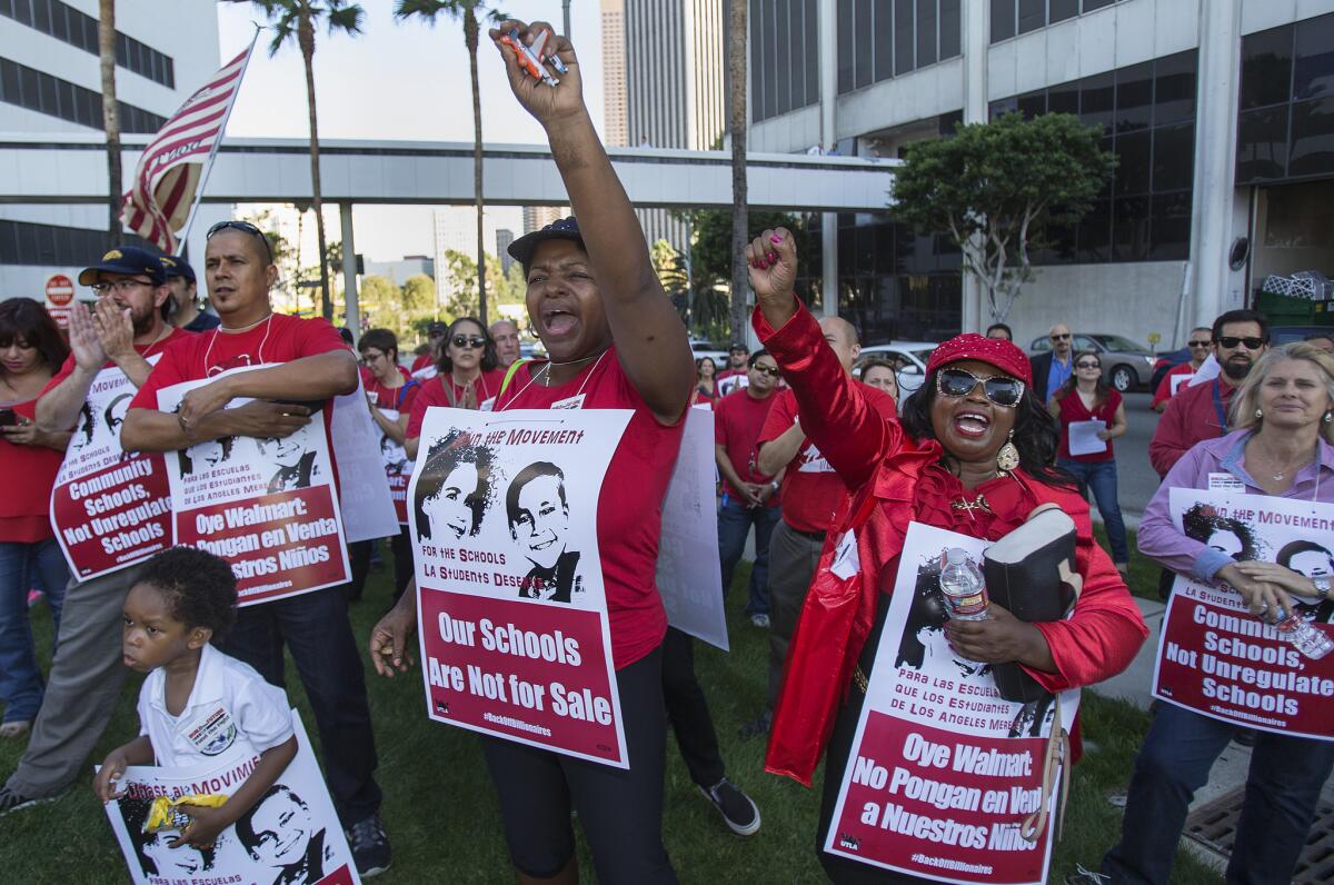 Protesters Carma Love, middle, with her son Massiah Garnett,3, and Linda Cardwell,right, cheer during a rally to take a stand against Eli Broad's charter expansion plan outside the LAUSD School Board meeting on October 13, 2015 in Los Angeles, California