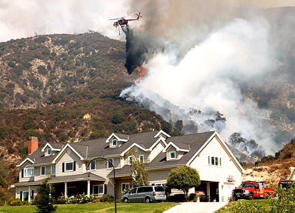Helicopters drop water on flames as they work their way downhill toward a home off Angeles Crest Highway. Residents near the Station fire in La Ca?ada Flintridge were waiting for possible evacuation orders.