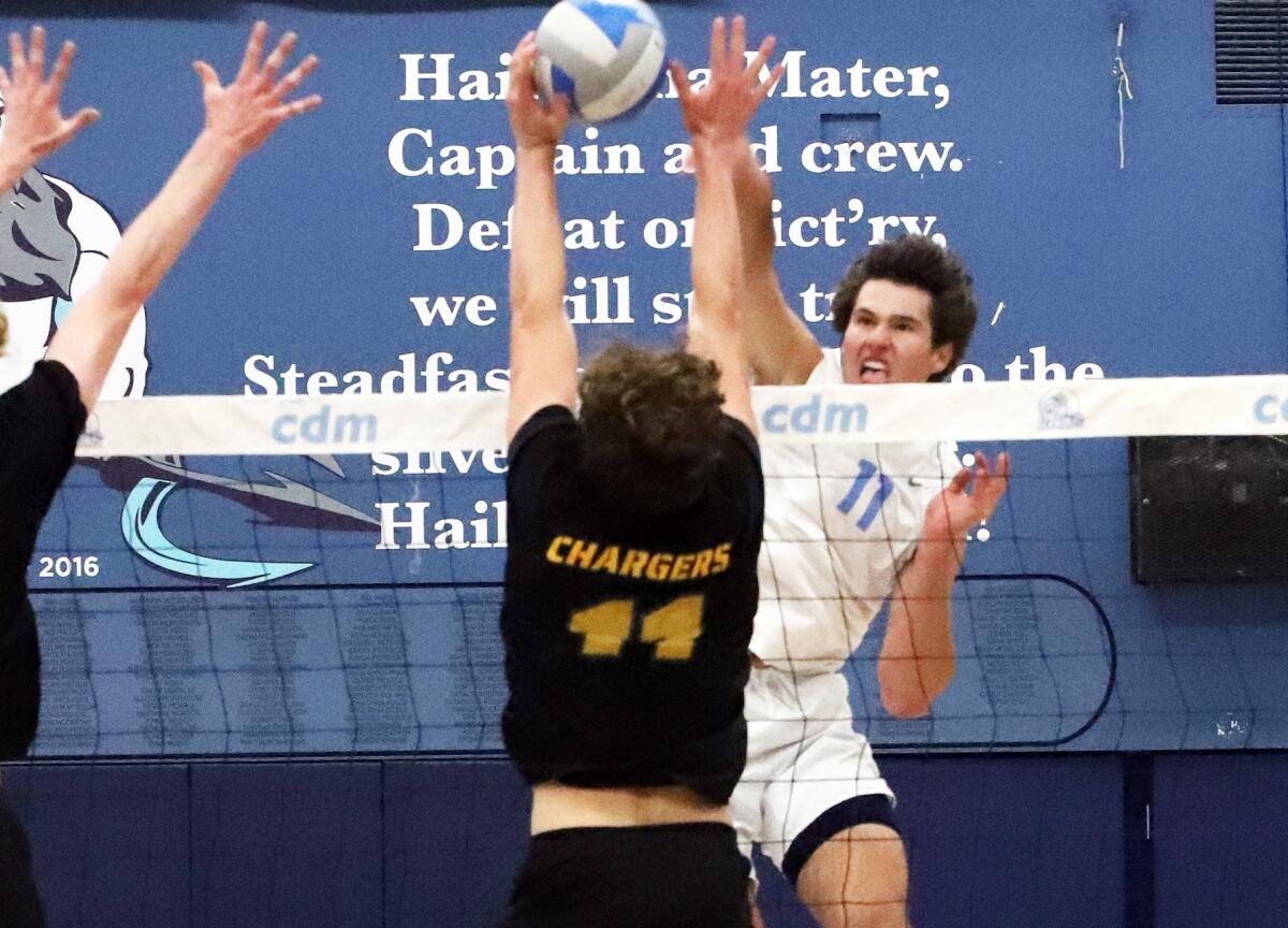 Corona del Mar's Sterling Foley hits against Edison's Connor McNally in a volleyball playoff match.