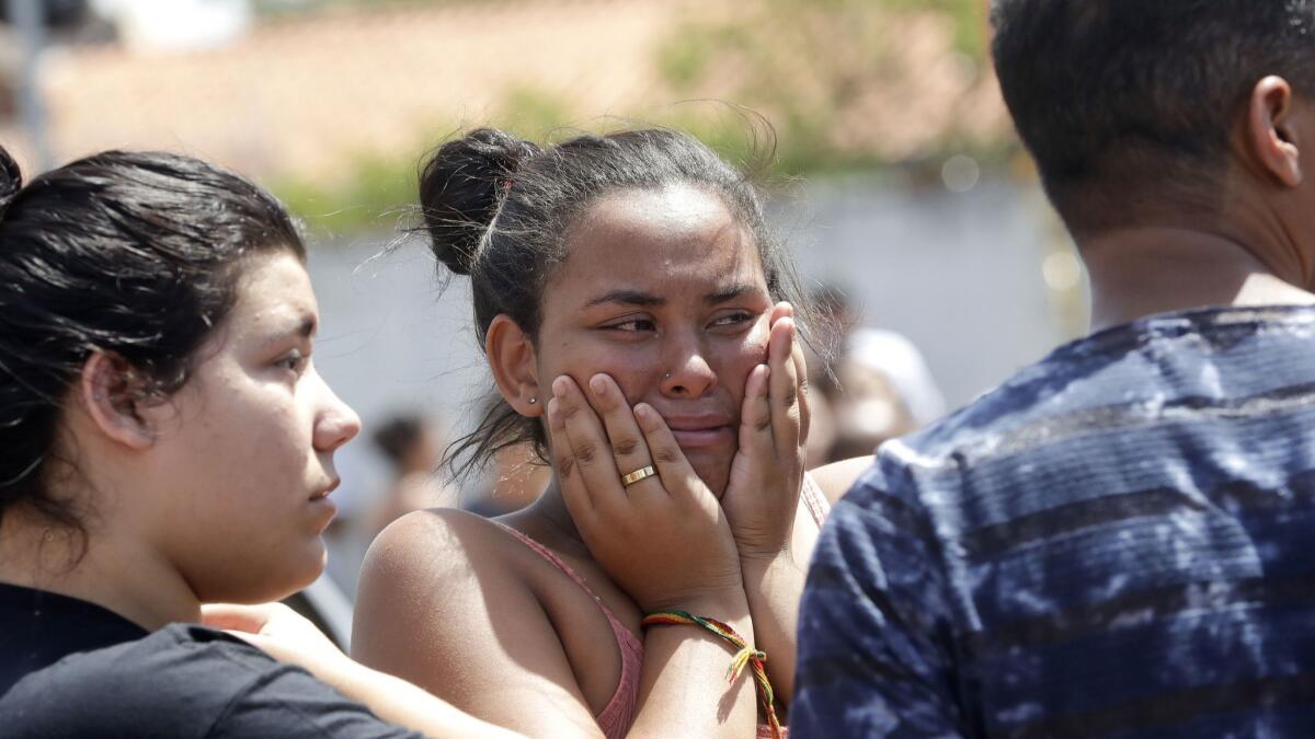 A student cries outside after a deadly attack on the Raul Brasil state school in Suzano, in Brazil's greater Sao Paulo area, on March 13, 2019.