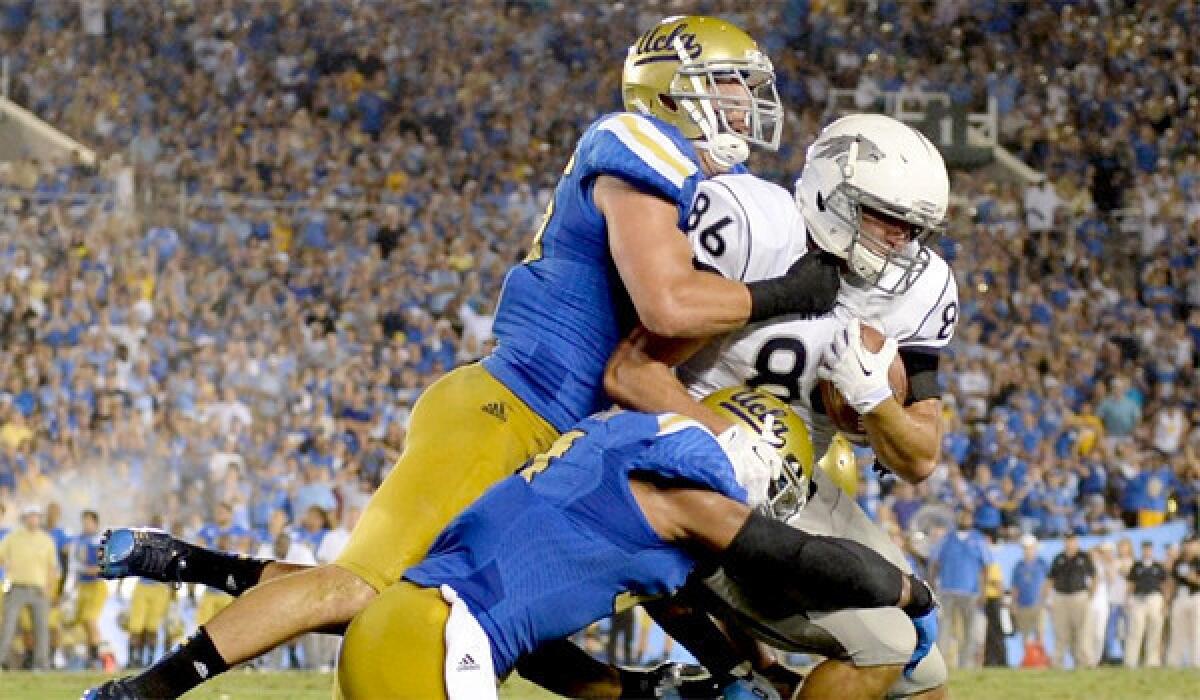 UCLA's Jordan Zumwalt, left, and Anthony Barr, center, tackle Nevada's Kolby Arendse on Aug. 31, 2013.