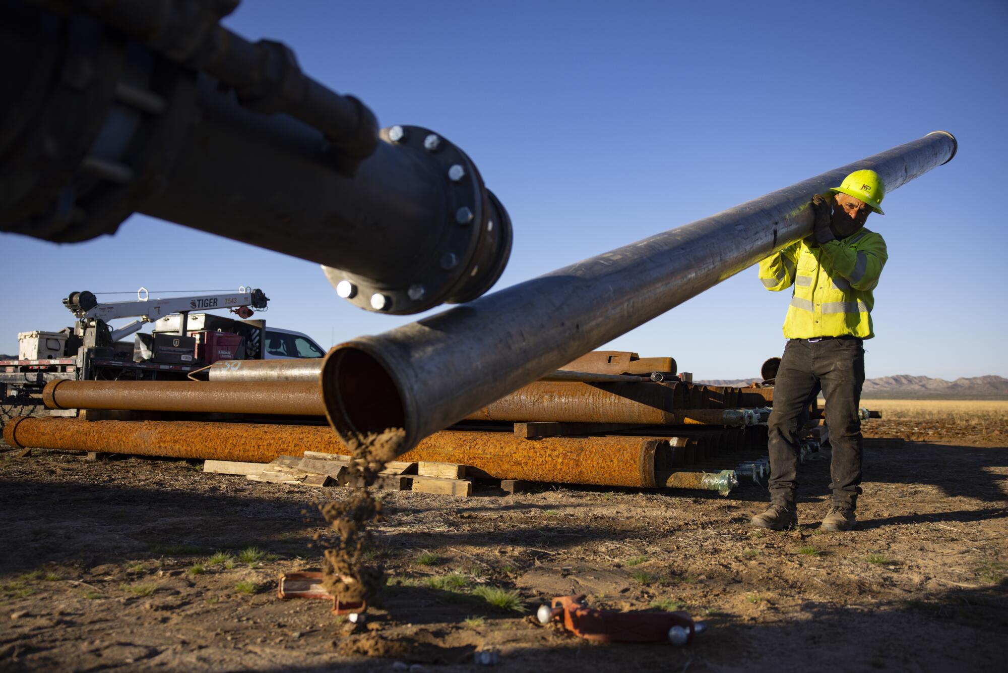 Worker Luis Machado dismantles a pipe after testing a water well in Butler Valley, Arizona.