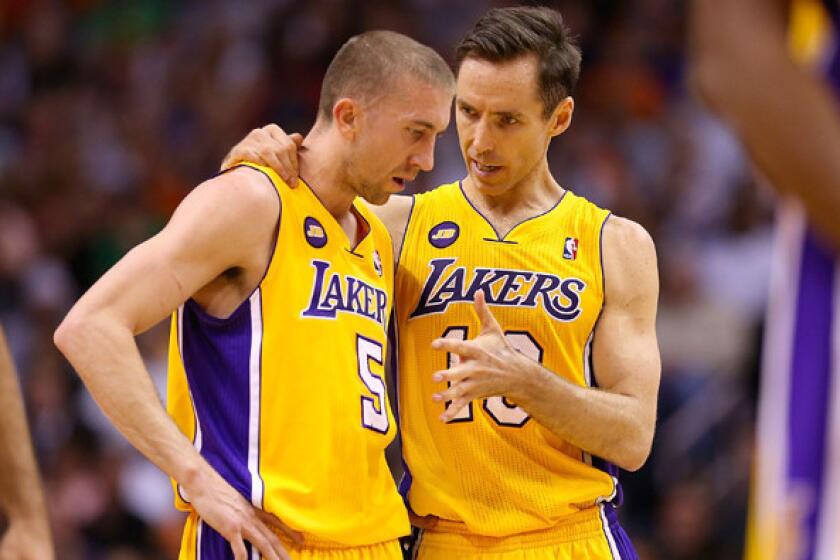 Lakers guard Steve Blake, left, speaks to teammate Steve Nash during a game in March 2013. Blake was traded to the Golden State Warriors on Wednesday.