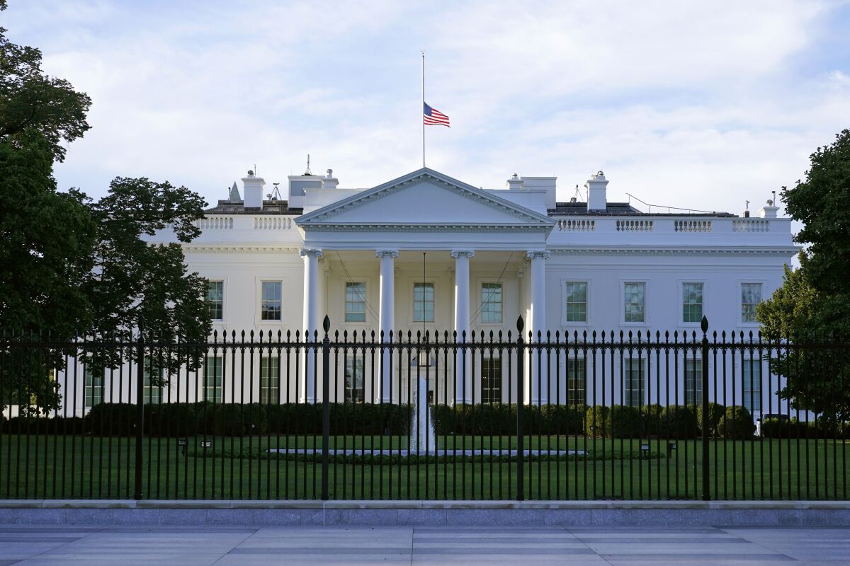 An American flag flies at half-staff over the White House on Saturday.