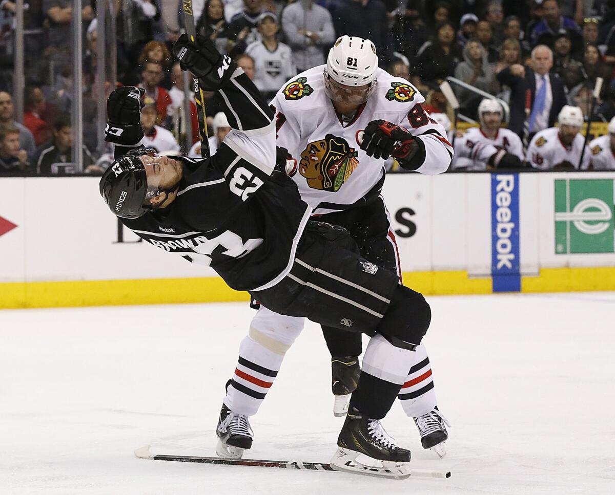 Kings right wing Dustin Brown is sent reeling after colliding with Blackhawks forward Marian Hossa in the third period.