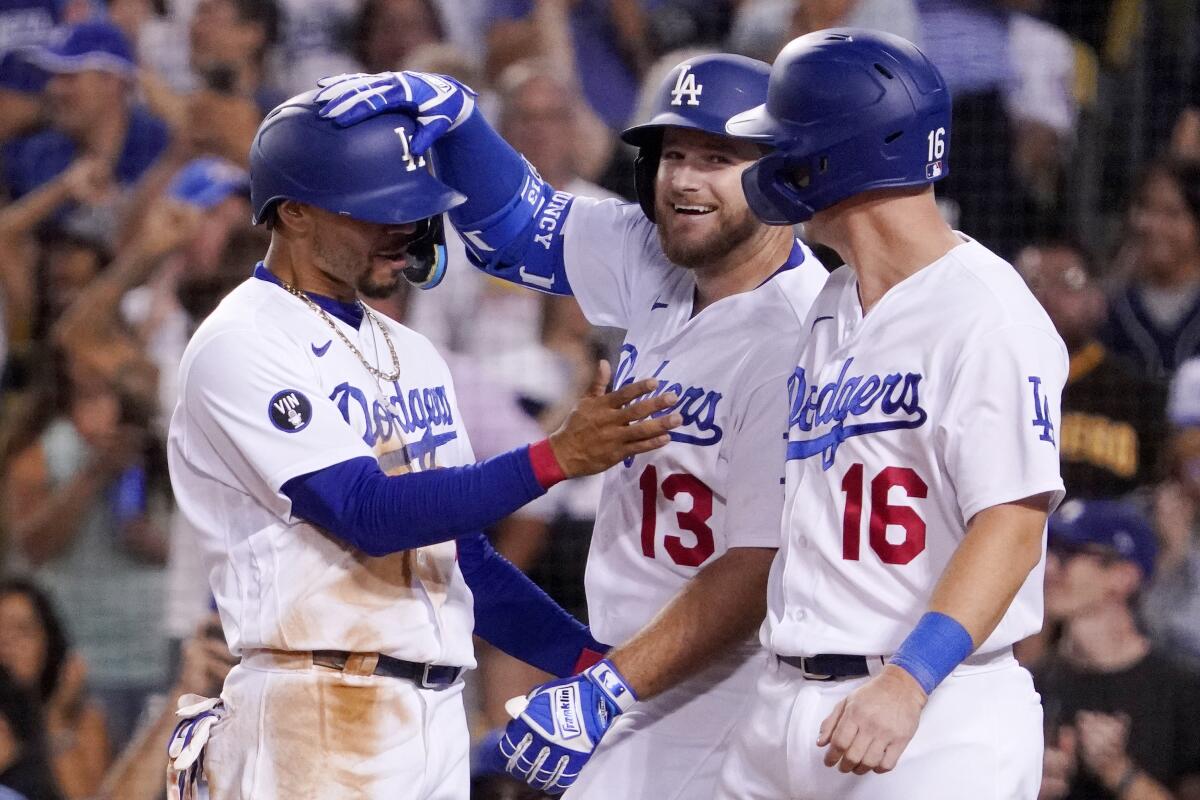 Max Muncy is congratulated by Dodgers teammates Mookie Betts and Will Smith after hitting a three-run home run.