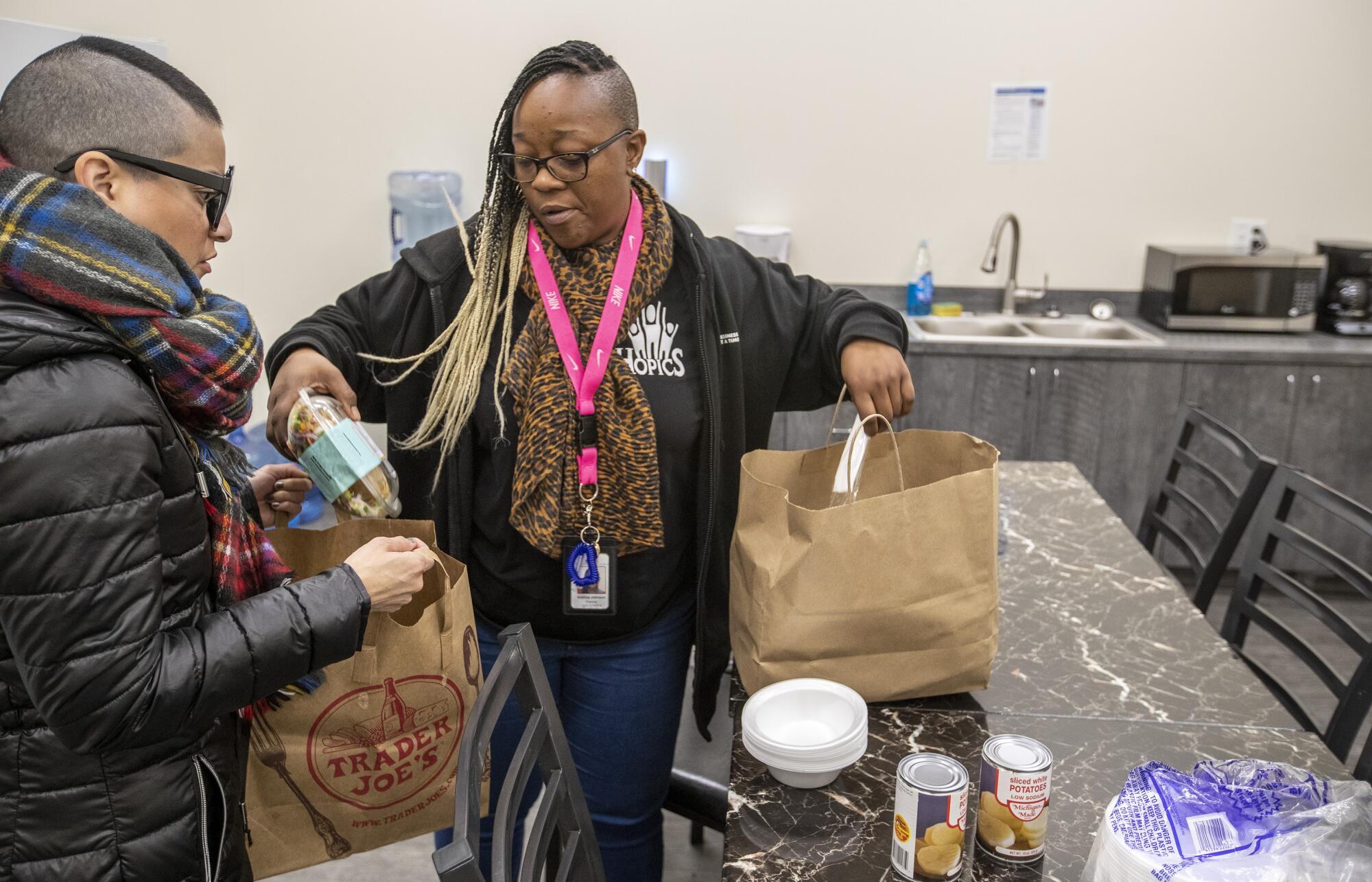 Outreach workers Denise Ramirez, left, and Katrina Johnson pack food to hand out to homeless people as part of their outreach program in Los Angeles.