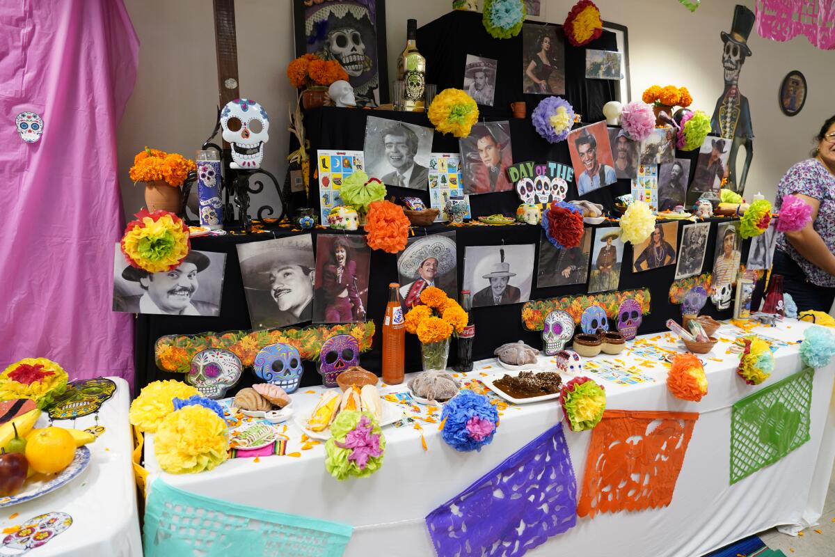 Altar decorated with black-and-white photos, colorful paper flowers and papel picado.