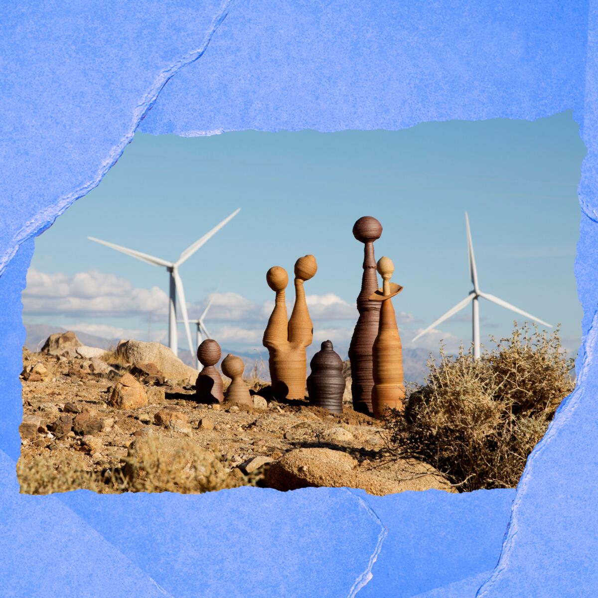 Brandon Lomax's sculptures poke up from the rocks, with giant wind turbines in the distance.