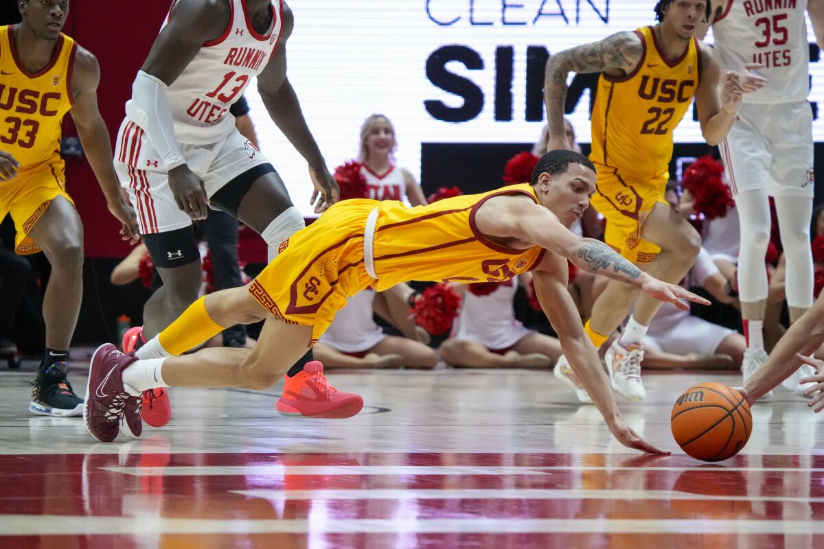 USC forward Kobe Johnson (0) dives for a loose ball during the first half.