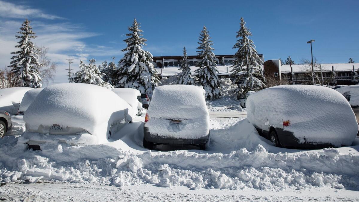 Snow covers vehicles in a parking lot in the Mammoth Lakes earlier this month.