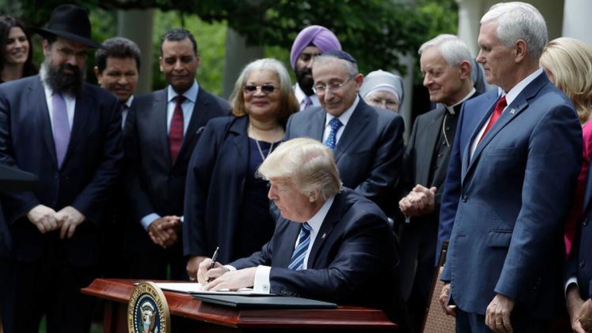 President Trump signs an order on religious freedom in May.