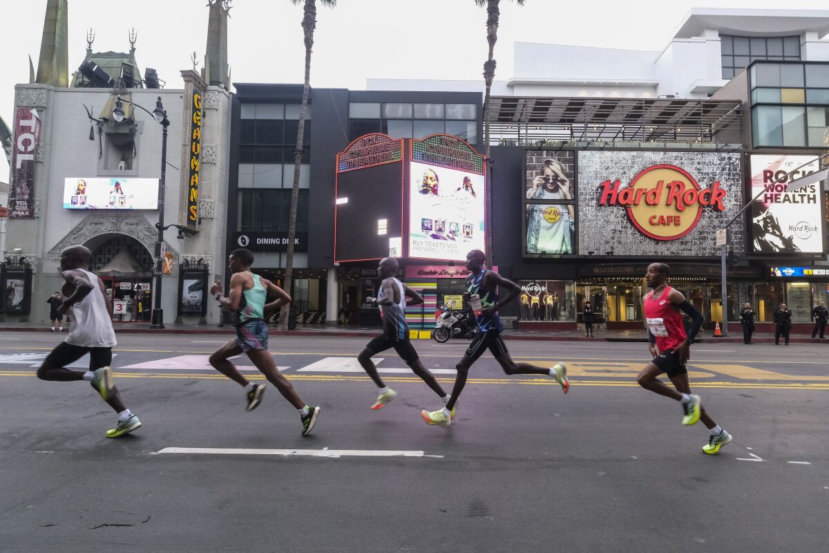 Men's elite runners pass the Hard Rock Cafe on Hollywood Boulevard.
