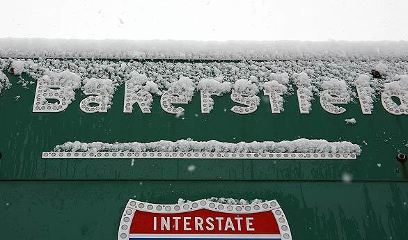 Snow accumulates on road signs in Gorman. Snow showers in the Tejon Pass area hamper driving but the California Highway Patrol has not closed that stretch of the Interstate 5.