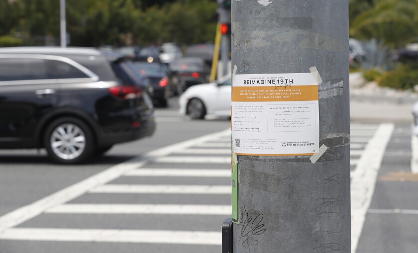 A "Reimagine 19th" flyer on the light signal post at Anaheim Ave and W. 19th St in Costa Mesa.