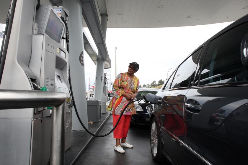 Eloise Ferguson of Ladera Heights pumps gas at a United Oil station at the intersection of Slauson and La Brea avenues in 2012.