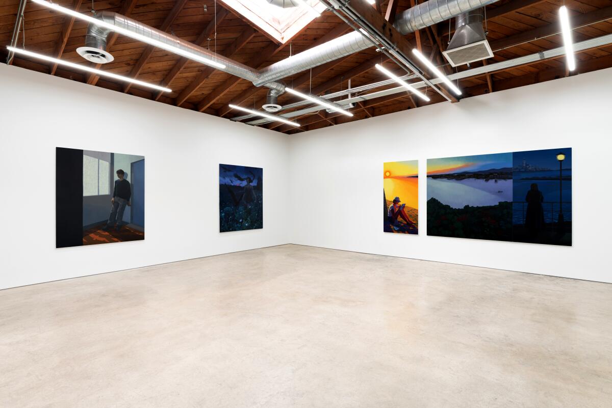 A gallery filled with paintings of people looking out into the distance.