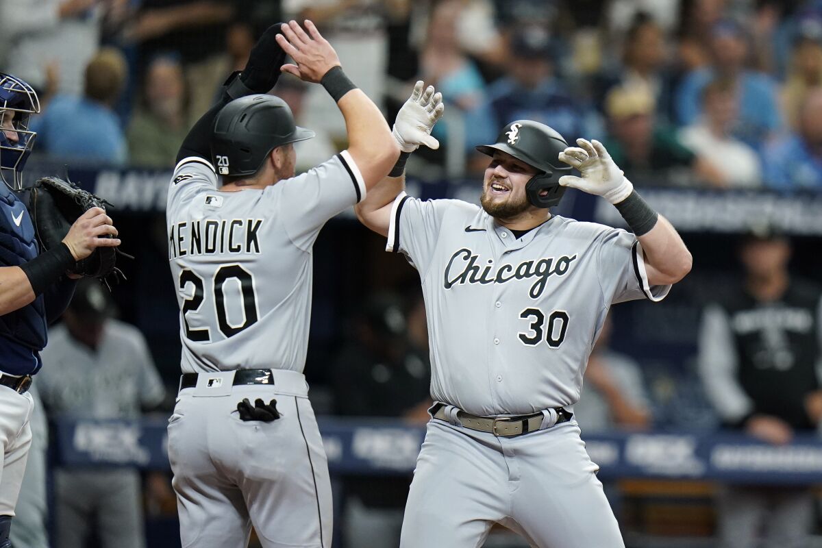 Chicago White Sox's Jake Burger (30) celebrates his two-run home run off Tampa Bay Rays relief pitcher Jalen Beeks with Danny Mendick (20) during the eighth inning of a baseball game Saturday, June 4, 2022, in St. Petersburg, Fla. (AP Photo/Chris O'Meara)