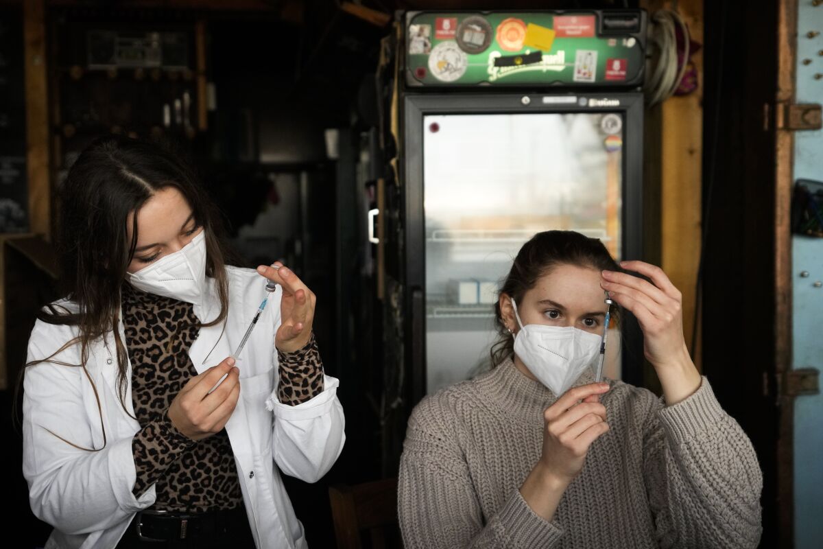 Personal médico prepara jeringas con vacunas contra el COVID-19 dentro del restaurante y club nocturno