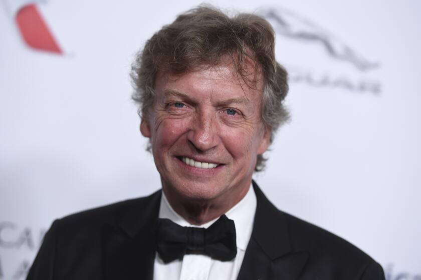 Nigel Lythgoe smiling in a black and white tuxedo