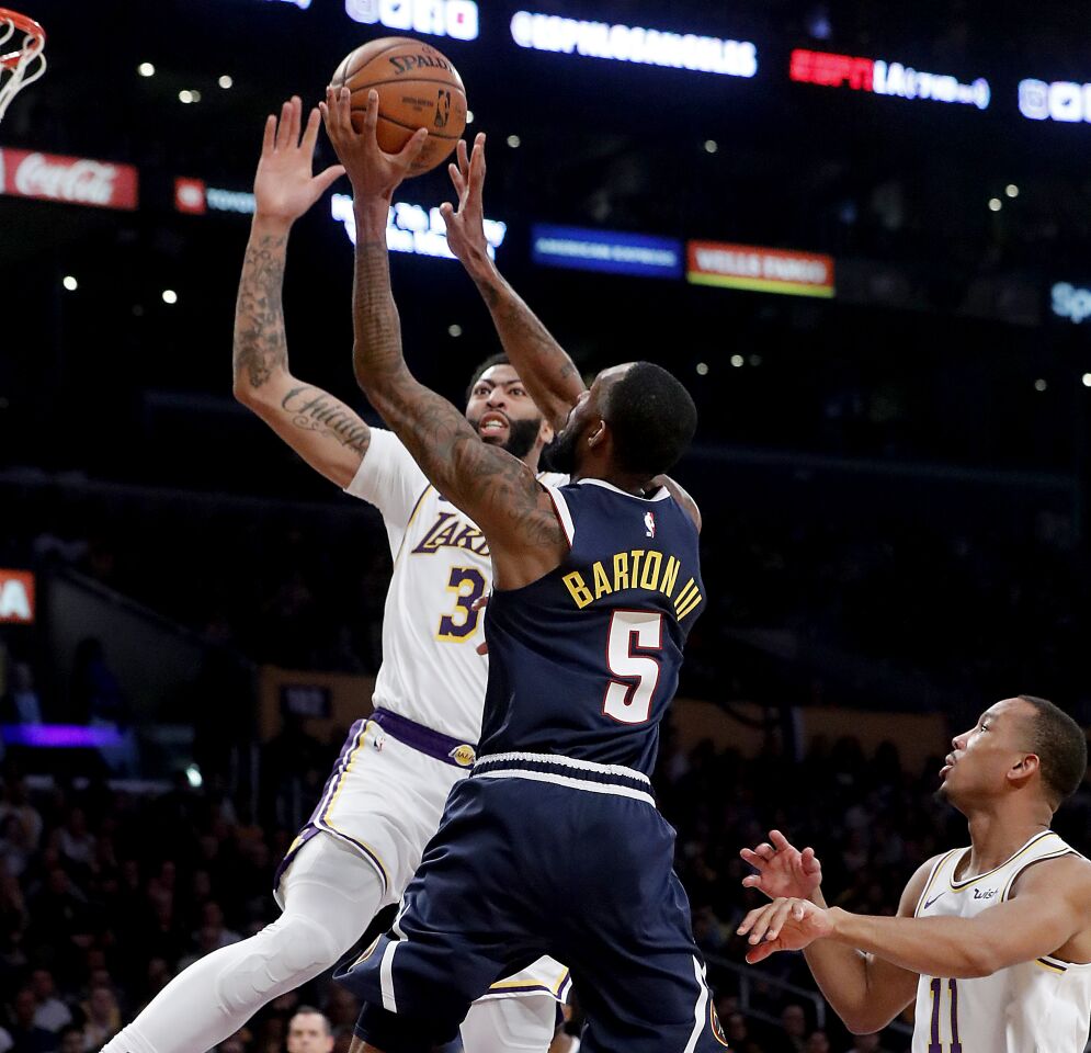 Lakers forward Anthony Davis challenges a shot by Nuggets forward Will Barton III during the third quarter.