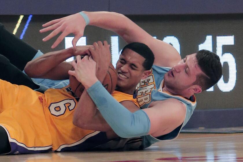 Jordan Clarkson is wrapped up by Denver center Jusuf Nurkic while battling for a loose ball during the first half of the Lakers' 106-96 loss to the Nuggets on Tuesday at Staples Center.