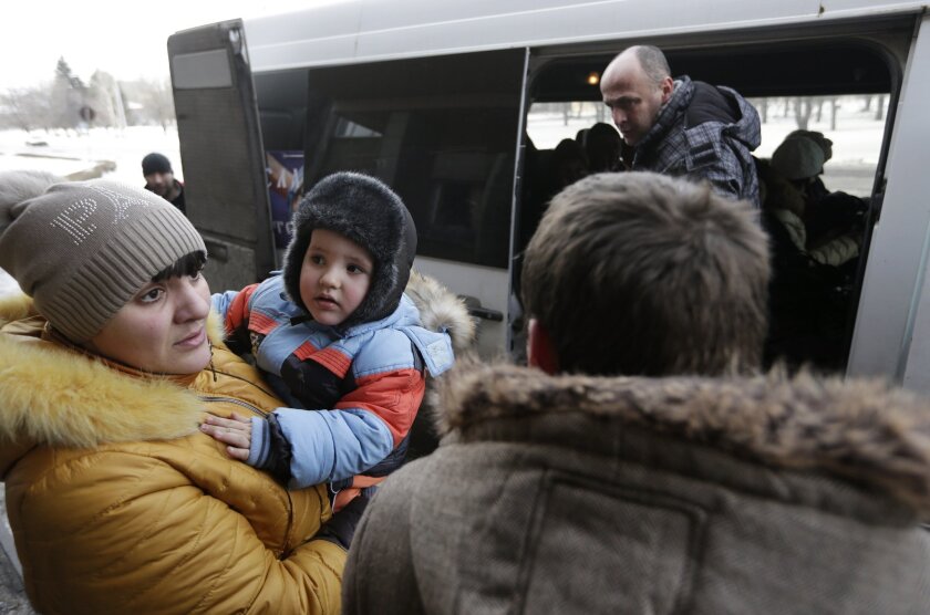 People board a bus to leave the town of Debaltseve, Ukraine, on Saturday.