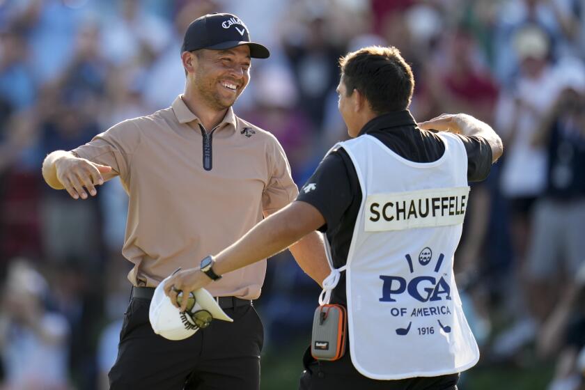 Xander Schauffele hugs his caddie Austin Kaiser after winning the final round of the PGA Championship golf tournament at the Valhalla Golf Club, Sunday, May 19, 2024, in Louisville, Ky. (AP Photo/Jeff Roberson)