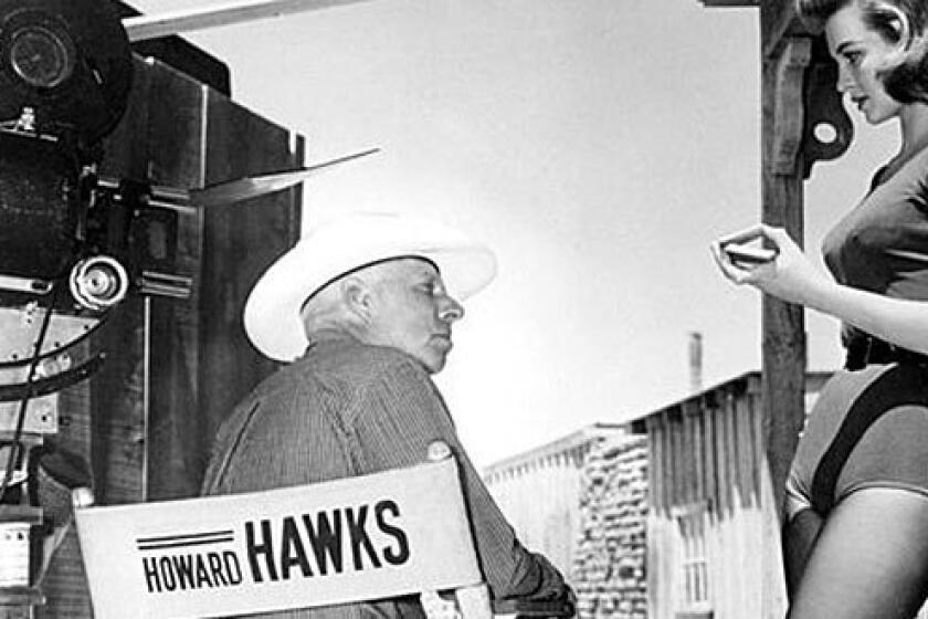 Director Howard Hawks with actress Angie Dickinson on the set of "Rio Bravo," 1959.