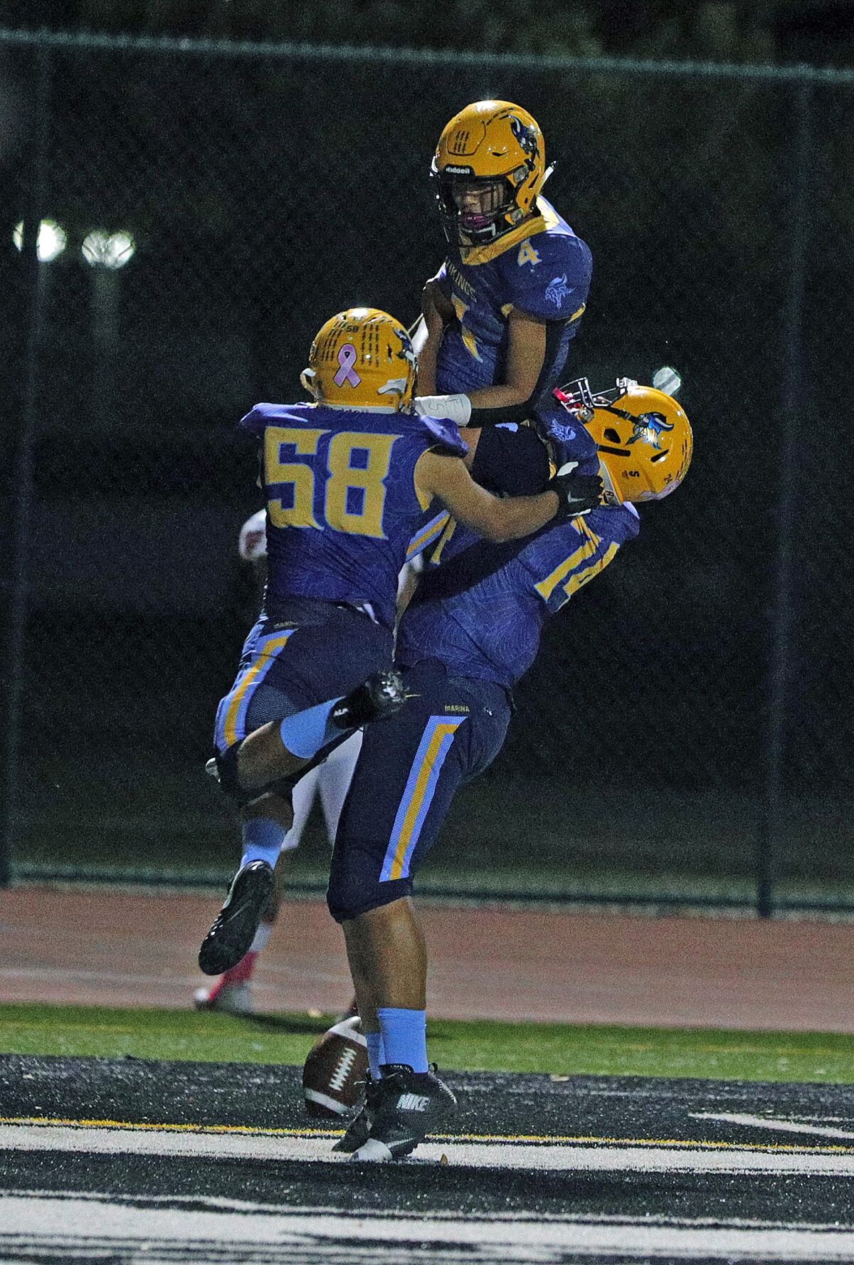 Marina's Angel Velasco (58) and Micah Norfles (74) hoist teammate Pharoah Rush into the air after scoring against Segerstrom in a Big 4 League game at Westminster High on Friday.