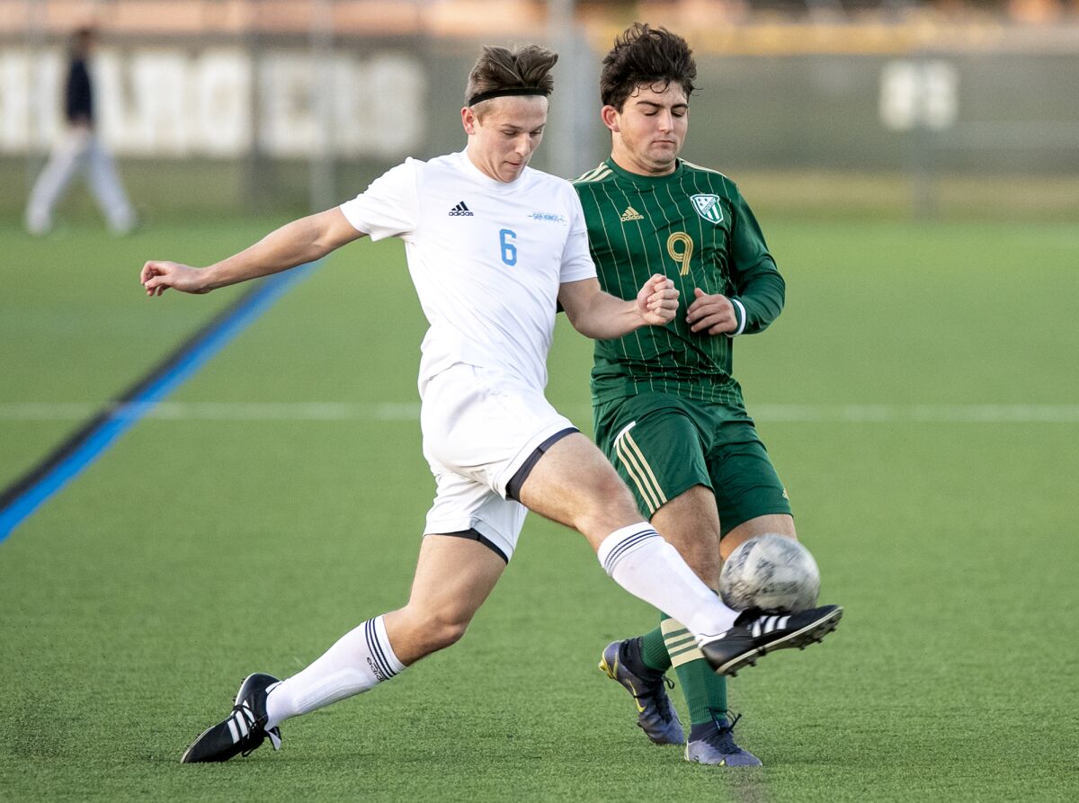 Corona del Mar's Colin Pene and Edison's Tai Khoshkbariie battle for a ball during a Surf League boys' soccer match.