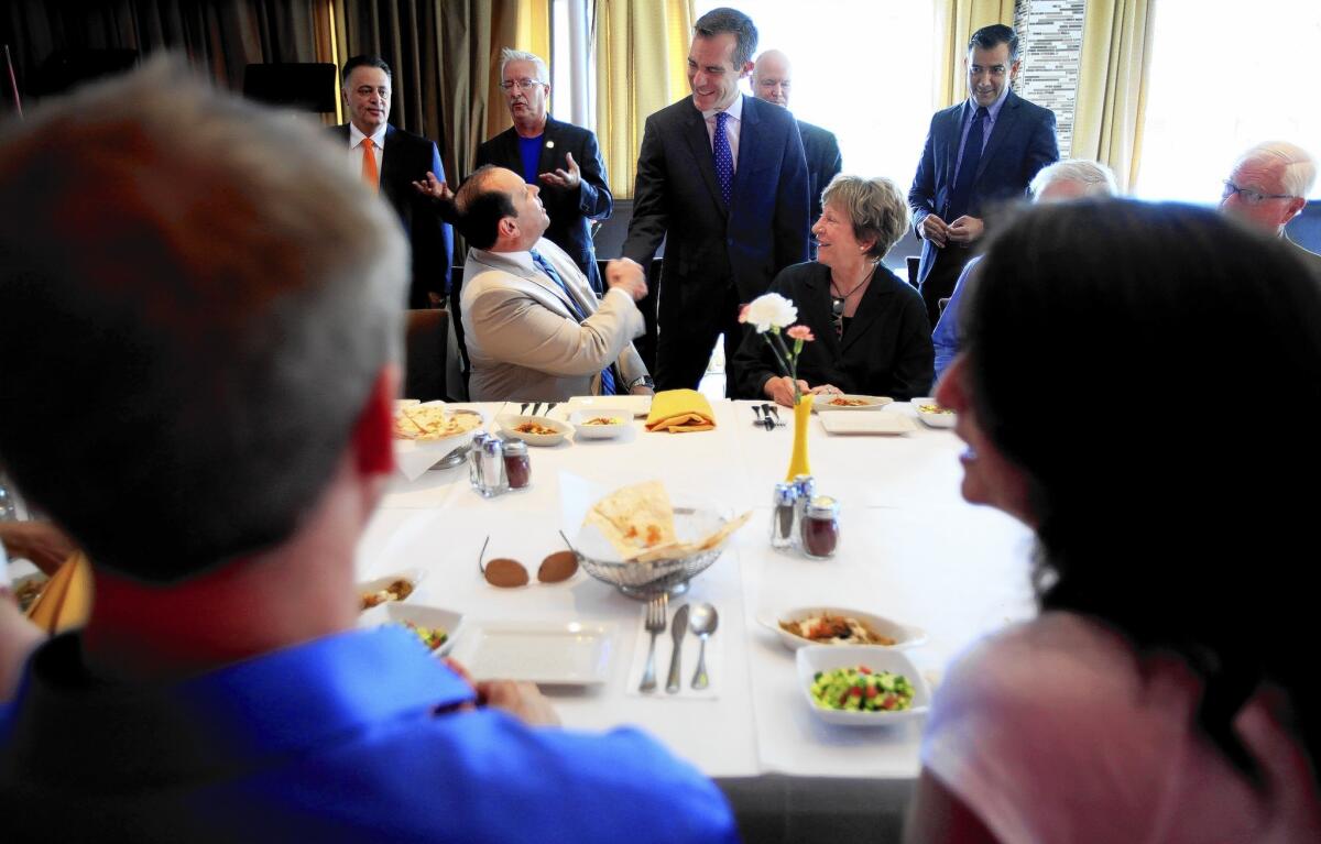 L.A. Mayor Eric Garcetti shakes hands with Steven Sann, chairman of the Westwood Community Council at a lunch with Westside leaders at Flame restaurant on Wednesday.