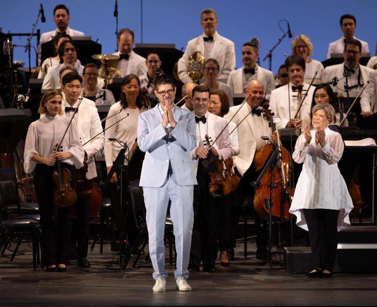 Composer Adam Schoenberg, in a sky blue suit, takes to the stage of the Hollywood Bowl during an ovation