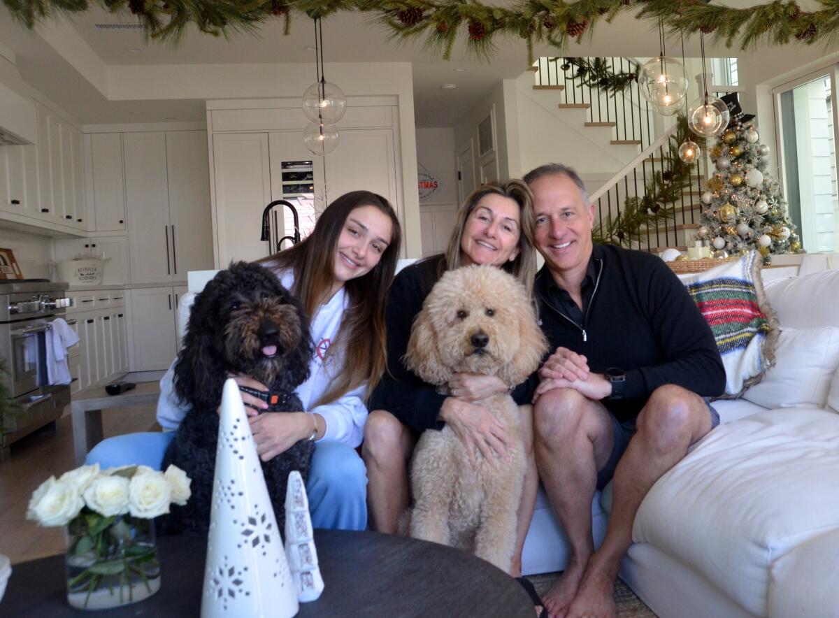 Inside their home decked out for Christmas are Sammi, Nilou and Dan Perry with dogs Jack and Jill.