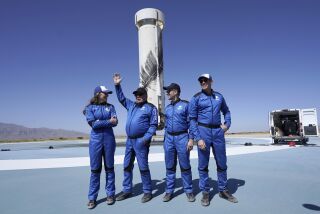 William Shatner, second from left, raises his hand while speaking with Audrey Powers, left, Chris Boshuizen, second from right and Glen de Vries raises during a media availability at the Blue Origin spaceport near Van Horn, Texas, Wednesday, Oct. 13, 2021. (AP Photo/LM Otero)