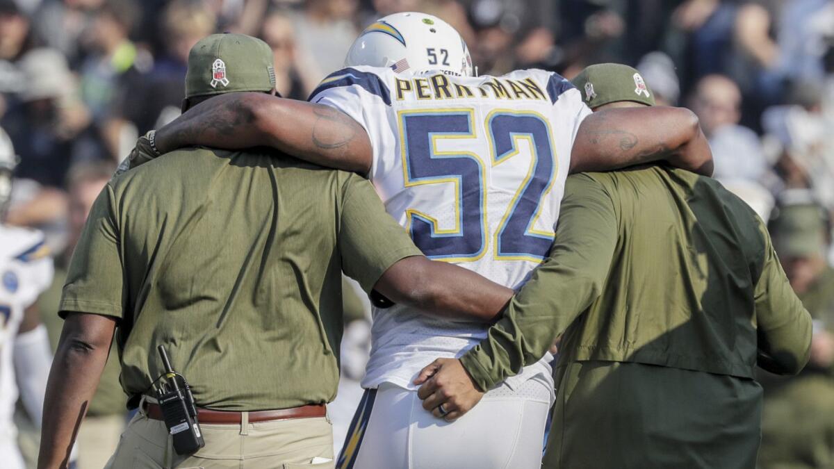 Chargers linebacker Denzel Perryman is helped off the field after sustaining an injury to his left knee.
