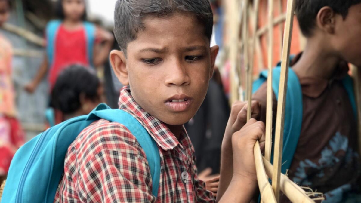 A Rohingya Muslim boy waits outside a makeshift learning center to attend informal classes at a refugee camp in Bangladesh in May 2018.