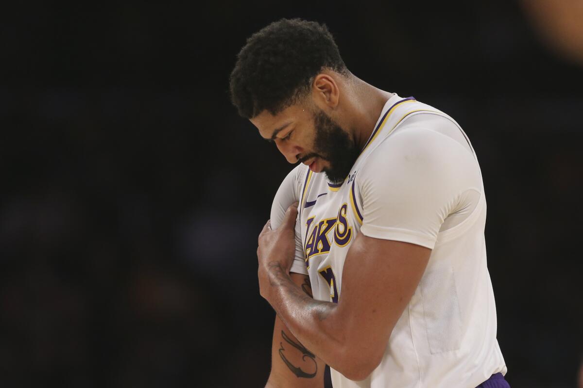 Lakers forward Anthony Davis clutches his shoulder during a break in the action against the Charlotte Hornets on Oct. 27, 2019.