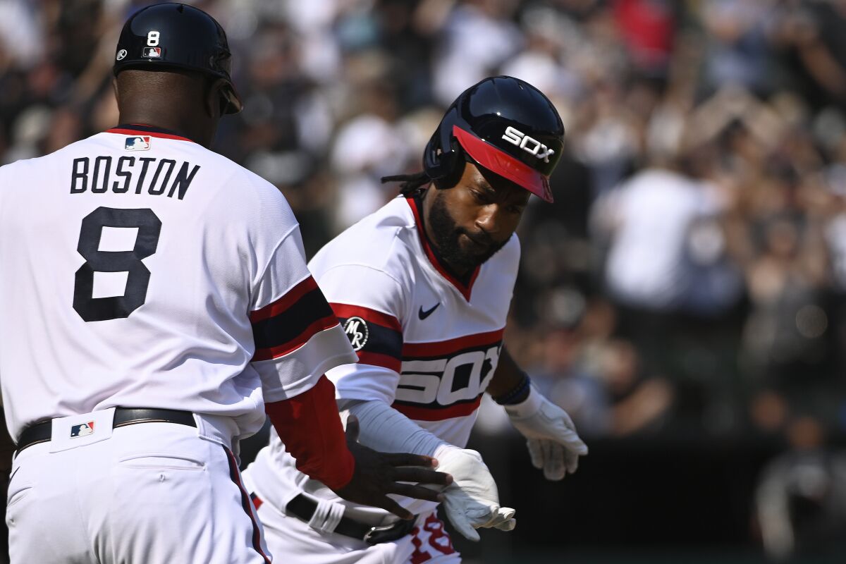 Chicago White Sox's Brian Goodwin, right, high-fives first base coach Daryl Boston (8) after hitting a walkoff home run during the ninth inning of a baseball game against the Cleveland Indians, Sunday, Aug. 1, 2021, in Chicago. (AP Photo/Matt Marton)