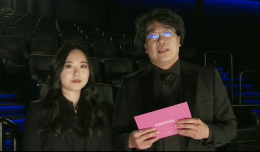 Sharon Choi standing next to Bong Joon Ho, holding a pink envelope