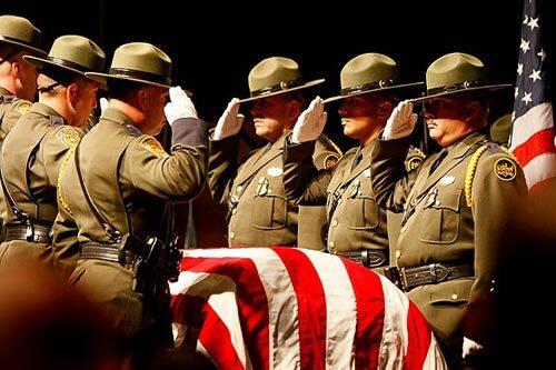 The Border Patrol honor guard stands at attention before carrying agent Robert Rosas' flag-draped coffin from a memorial service at the Southwest High School theater in El Centro.